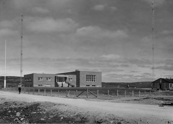 <p>Illustrasjon 1 – Finnmark kringkaster 1950. De store sendemastene er synlig på hver side av bygget.  Foto: Henry Hansen/Varanger museum avd. Vadsø museum – Ruija kvenmuseum  </p>